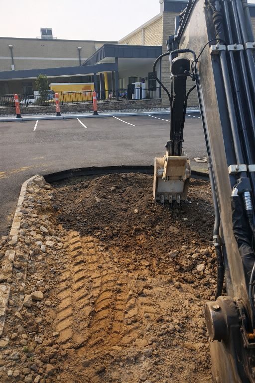 GradeCraft excavator digging commercial parking lot site — professional excavation services Warren County NJ